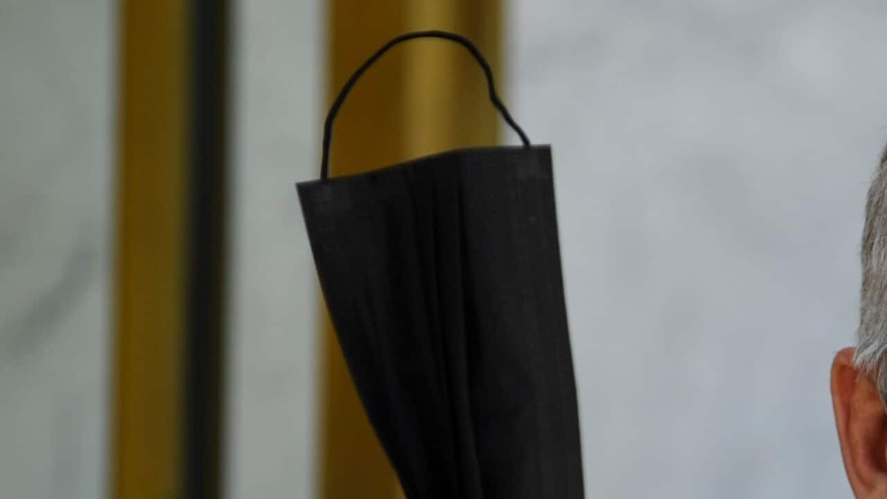 Australian Prime Minister Scott Morrison holds up a face mask as he speaks during a press conference