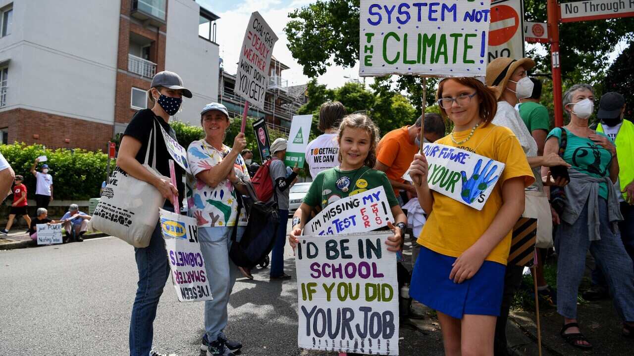 Protesters hold placards during a Climate School Strike protest at Kirribilli House in Sydney, Friday, March 25, 2022.