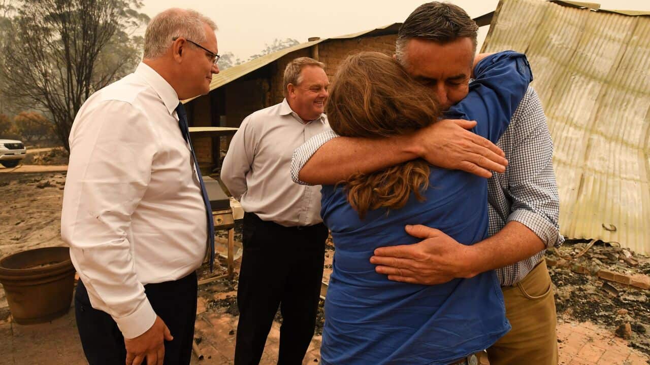 Australia's Prime Minister Scott Morrison (L) and MP Darren Chester (R) visit an area devastated by bushfires in Sarsfield, Victoria, 3 January, 2020.