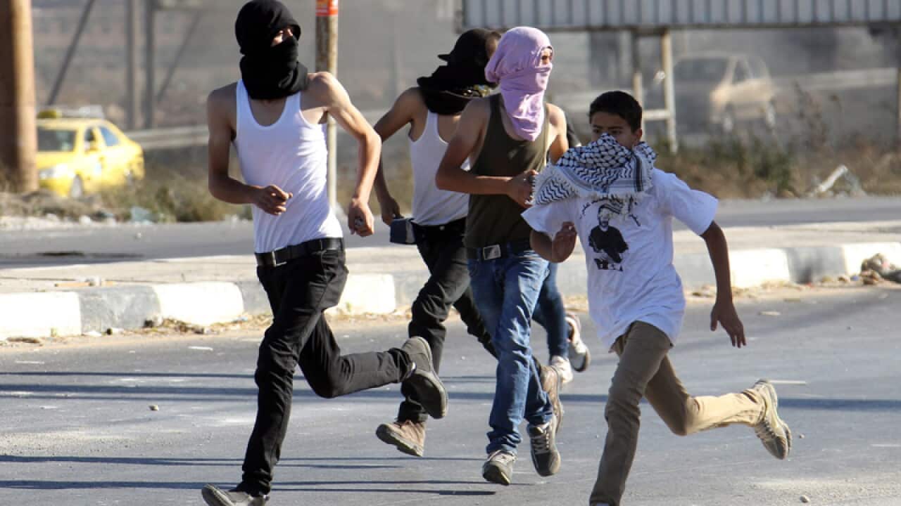 Palestinian teenagers run during clashes with Israeli soldiers.