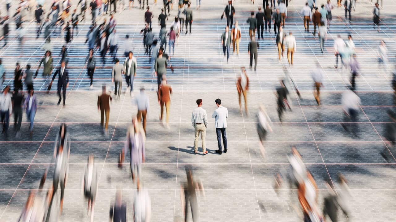 Businessmen on the street standing in crowds of walking people