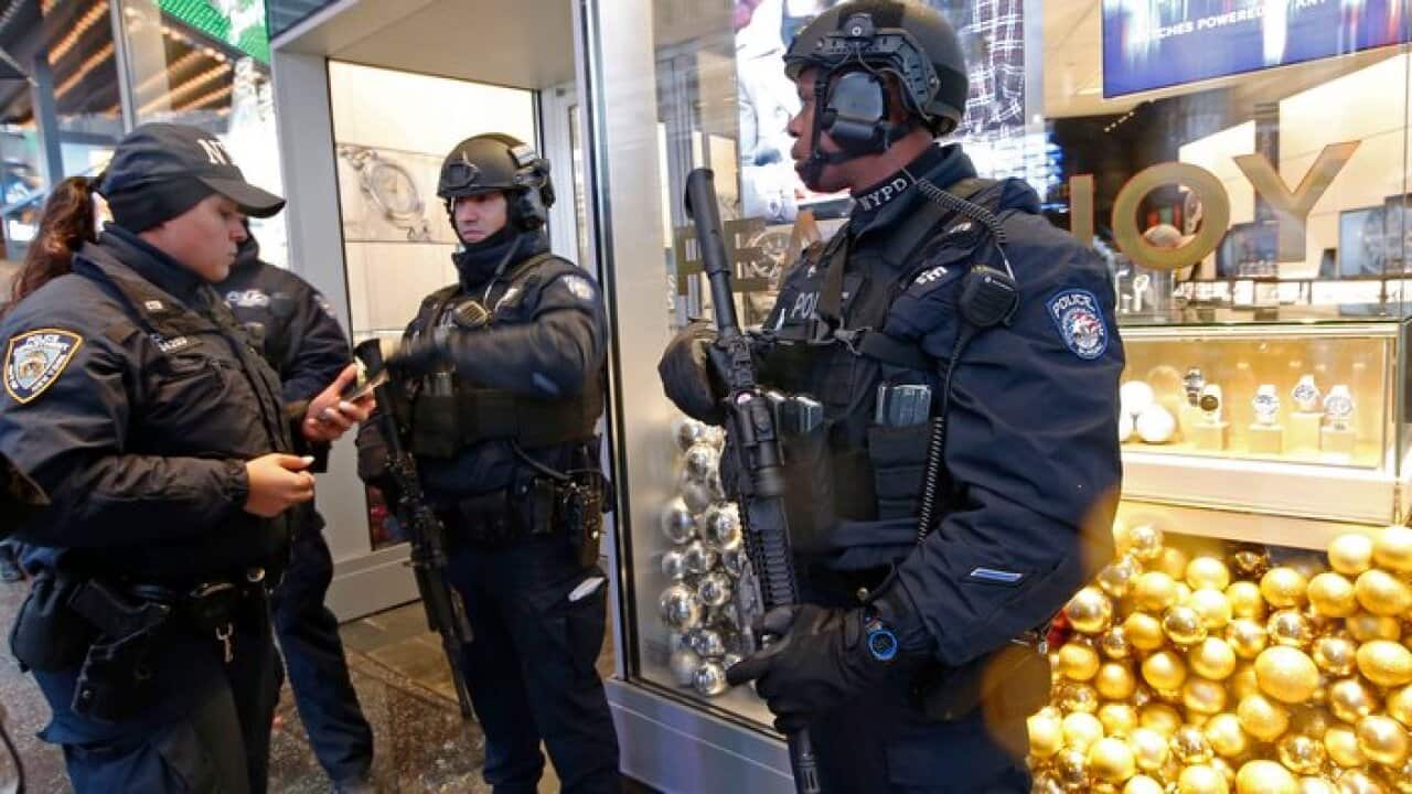 Counterterrorism officers stand in front of a watch store in Times Square