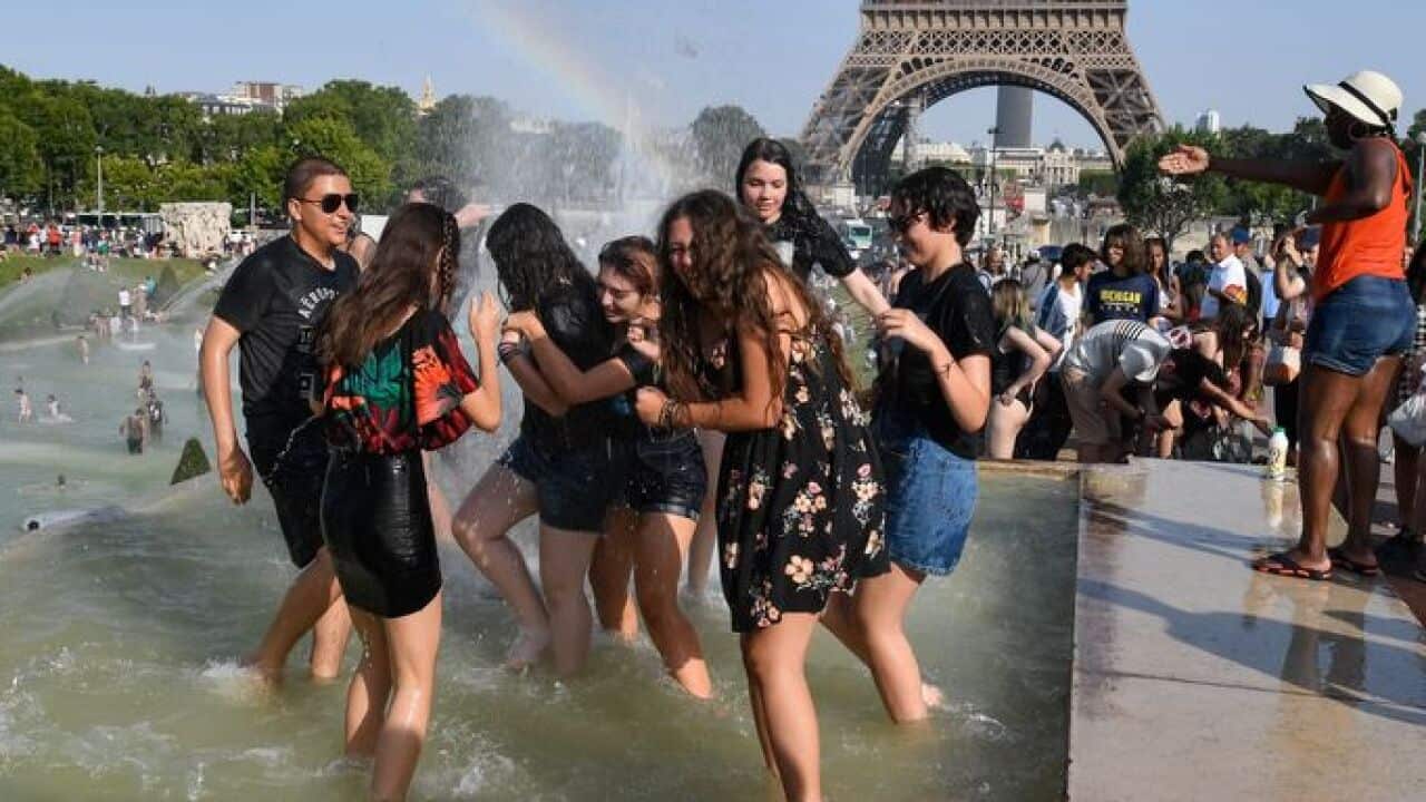People cool off at the Trocadero Fountains next to the Eiffel Tower in Paris, on July 23, 2019 as a new heatwave hits Europe.