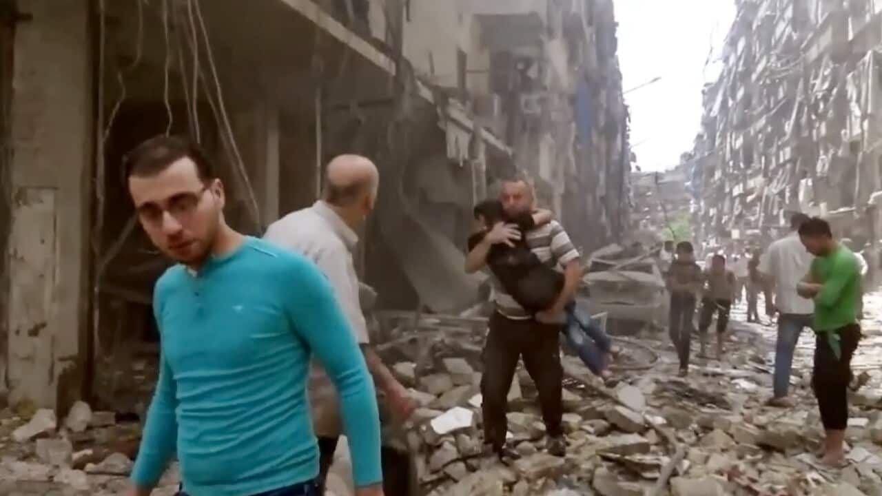 A man carries a child after airstrikes hit Aleppo, Syria.