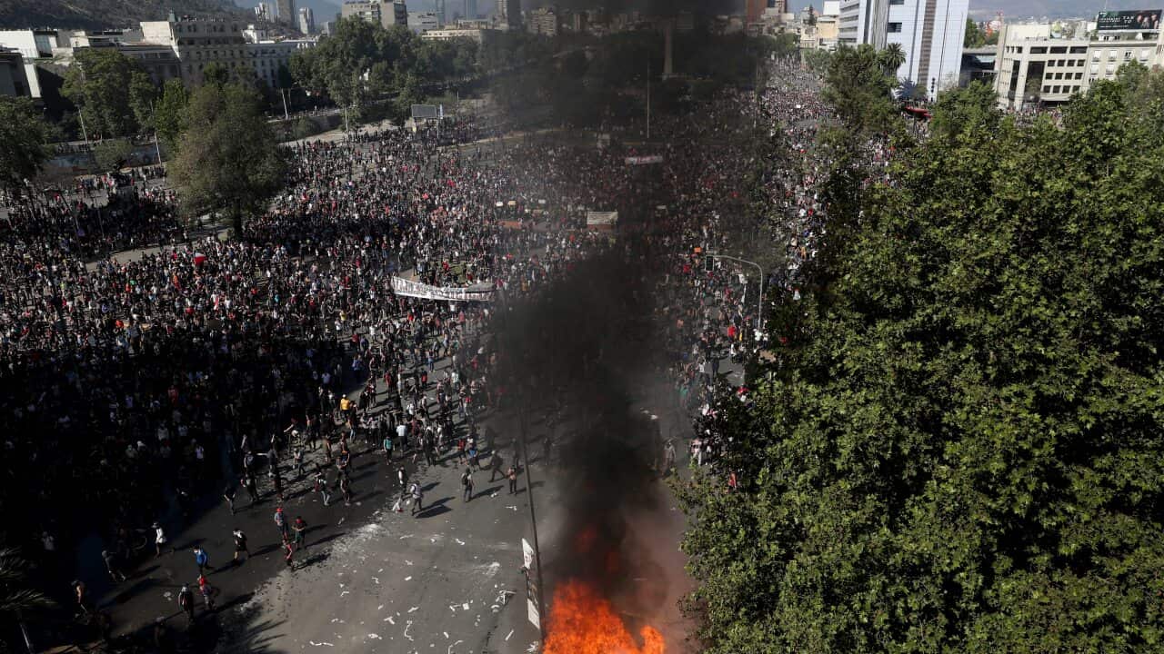 Anti-government protesters take part in a ongoing demonstrations triggered by an increase in subway fares in Santiago, Chile, 21 October.