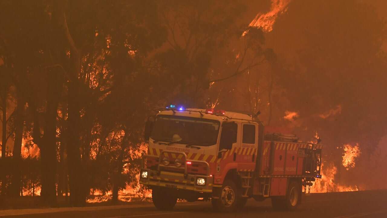 Rural Fire Service (RFS) crews battle the bushfires near homes along the Old Hume Highway near the town of Tahmoor.