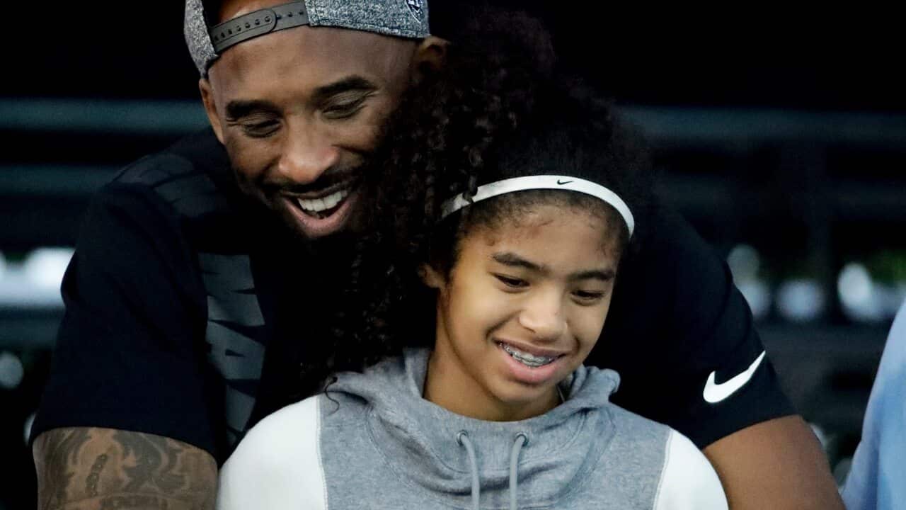 Kobe Bryant and his daughter Gianna watch during the national championships swimming meet in 2018.
