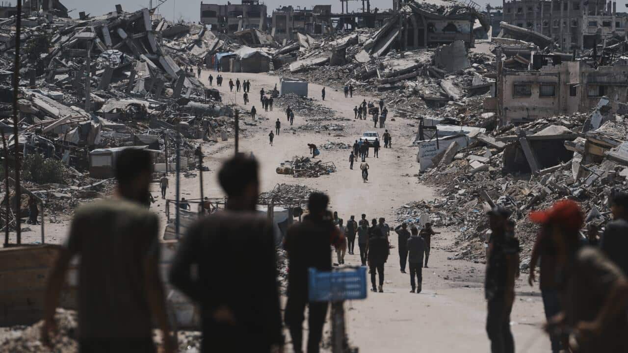 Peopel walking along a dirt road.