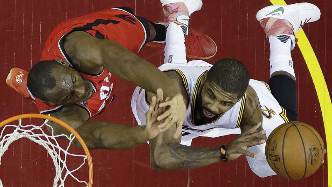 Cleveland Cavaliers' Kyrie Irving (R)and Toronto's Bismack Biyombo