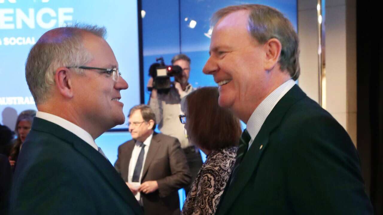 Former Australian Treasurer Peter Costello (left) speaks with Australian Prime Minister Scott Morrison