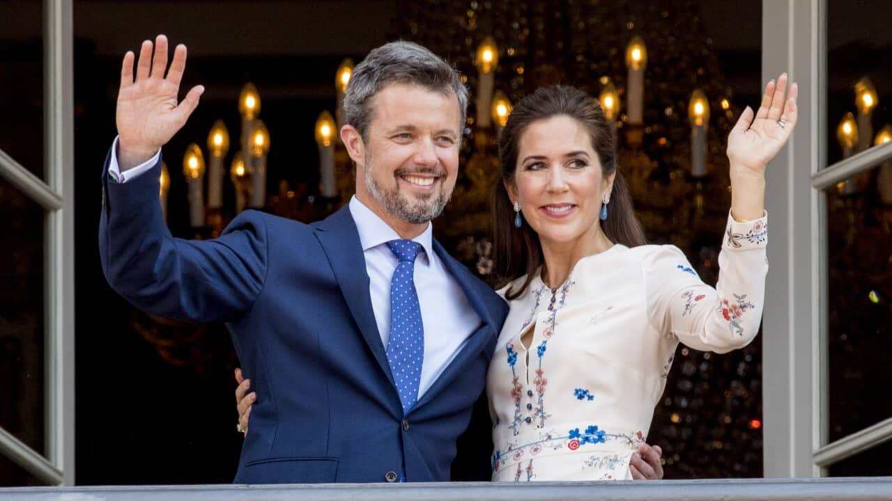 Prince Frederik and Princess Mary wave from a balcony