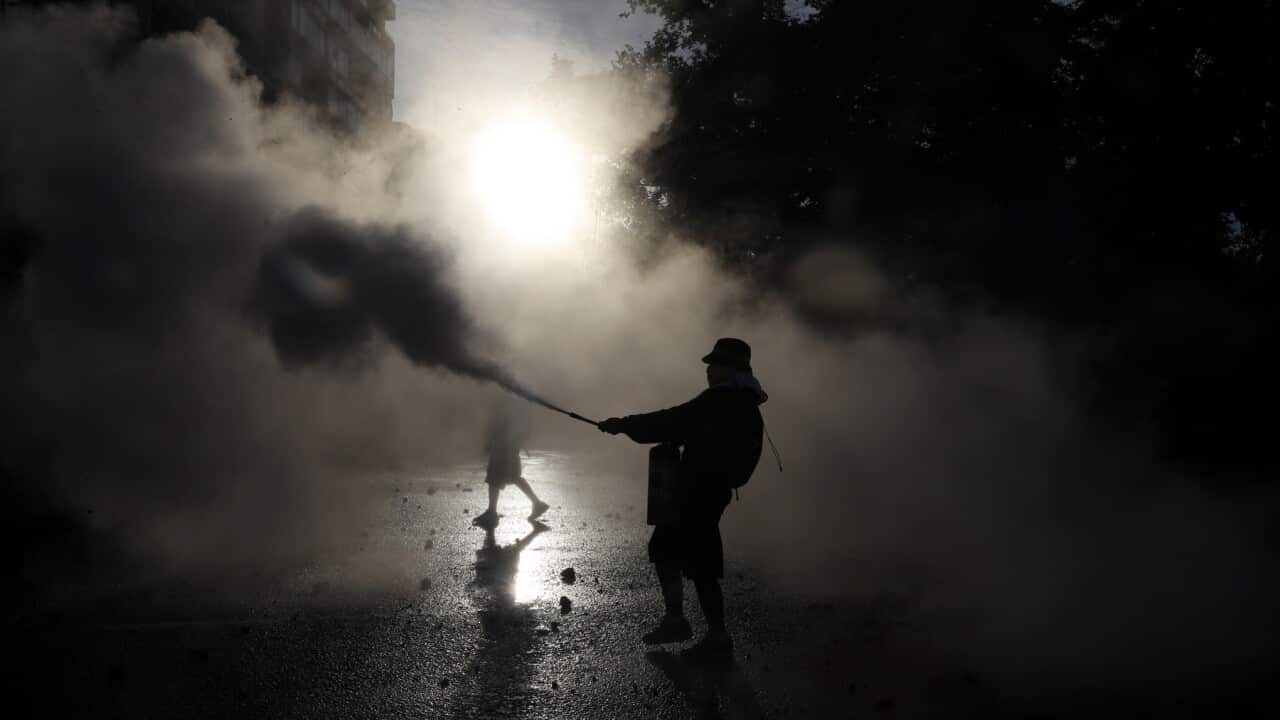 An anti-government protester sprays a fire extinguisher in Santiago, Chile