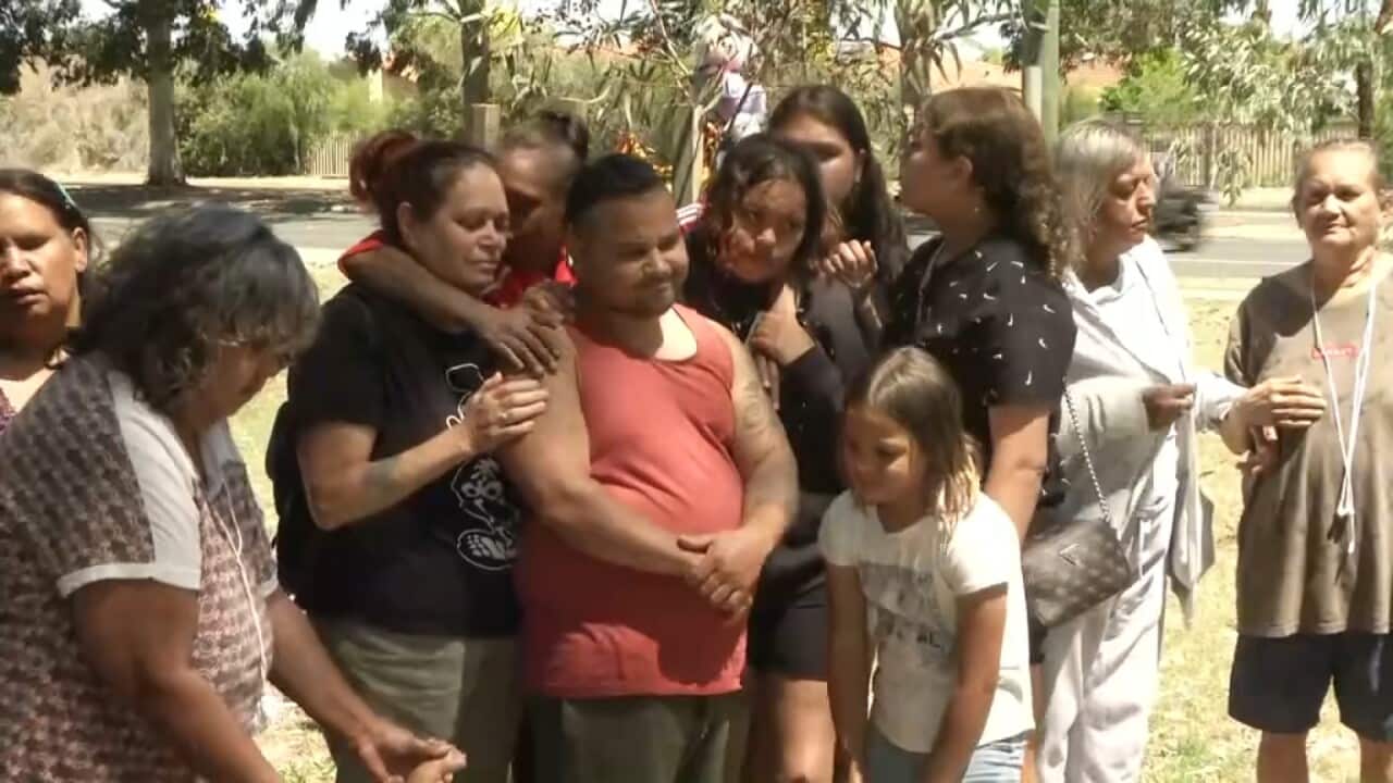 family embrace at a press conference