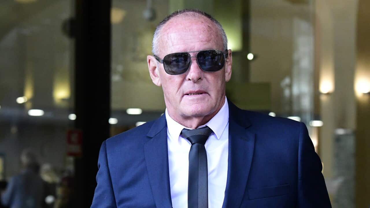 A man in a suit and dark glasses