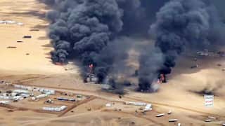 Thick black smoke blankets a desert landscape