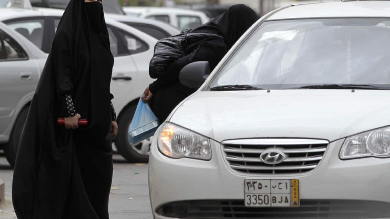 Saudi women board a taxi