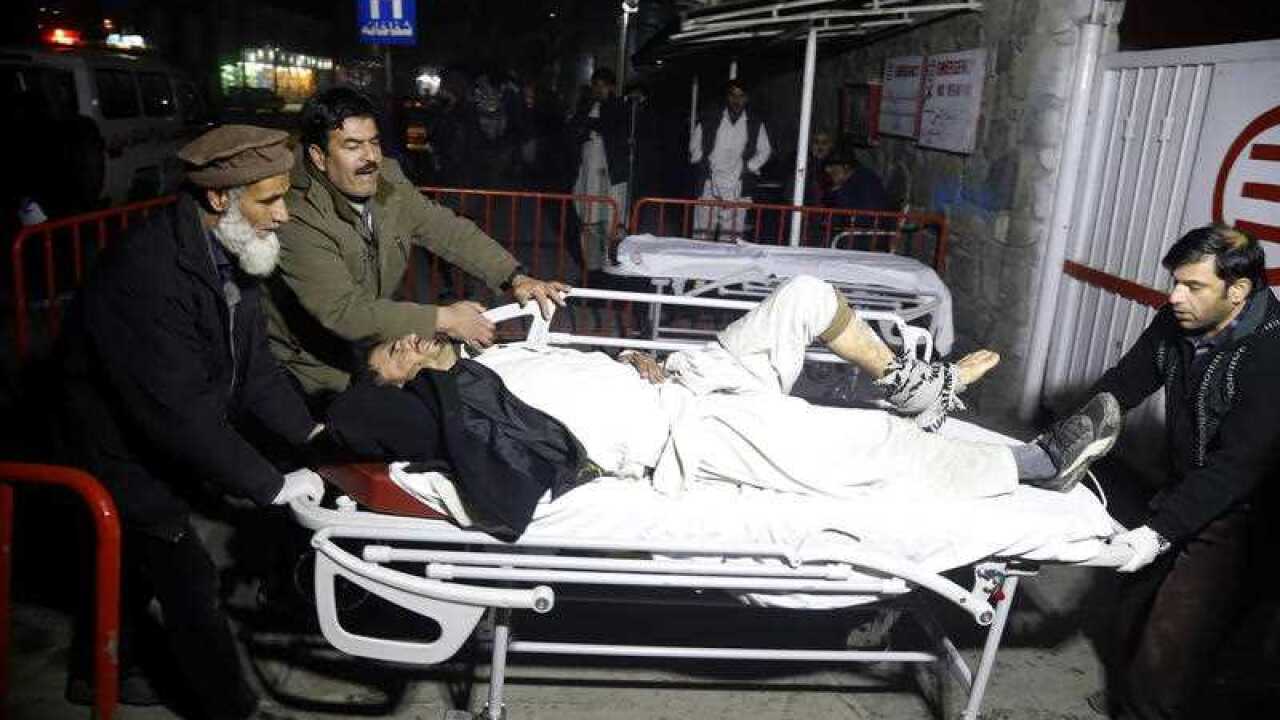 Afghan health workers carry an injured man to an emergency hospital after a truck bomb blast in Kabul, Afghanistan.