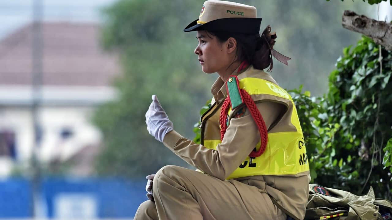A Lao traffic police woman takes a break outside the National Convention Center in Vientiane (ROSLAN RAHMAN - AFP via Getty Images)