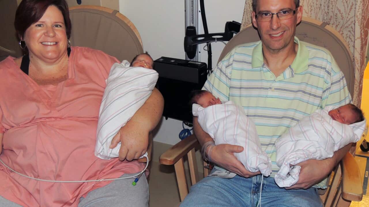 April and Brad Dooley holding their identical triplets, Calif.