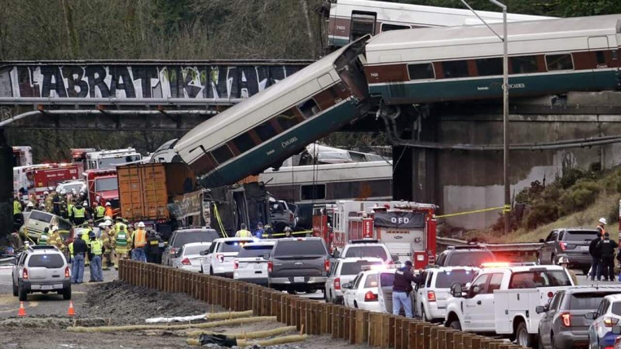 Cars from an Amtrak train lay spilled onto Interstate