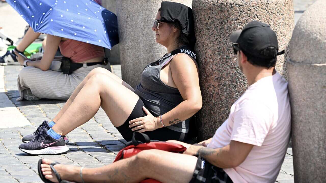 Tourists and faithful shelter from the sun while waiting for Pope Francis' Angelus prayer, at Saint Peter's Square, Vatican City, 23 July 2023.