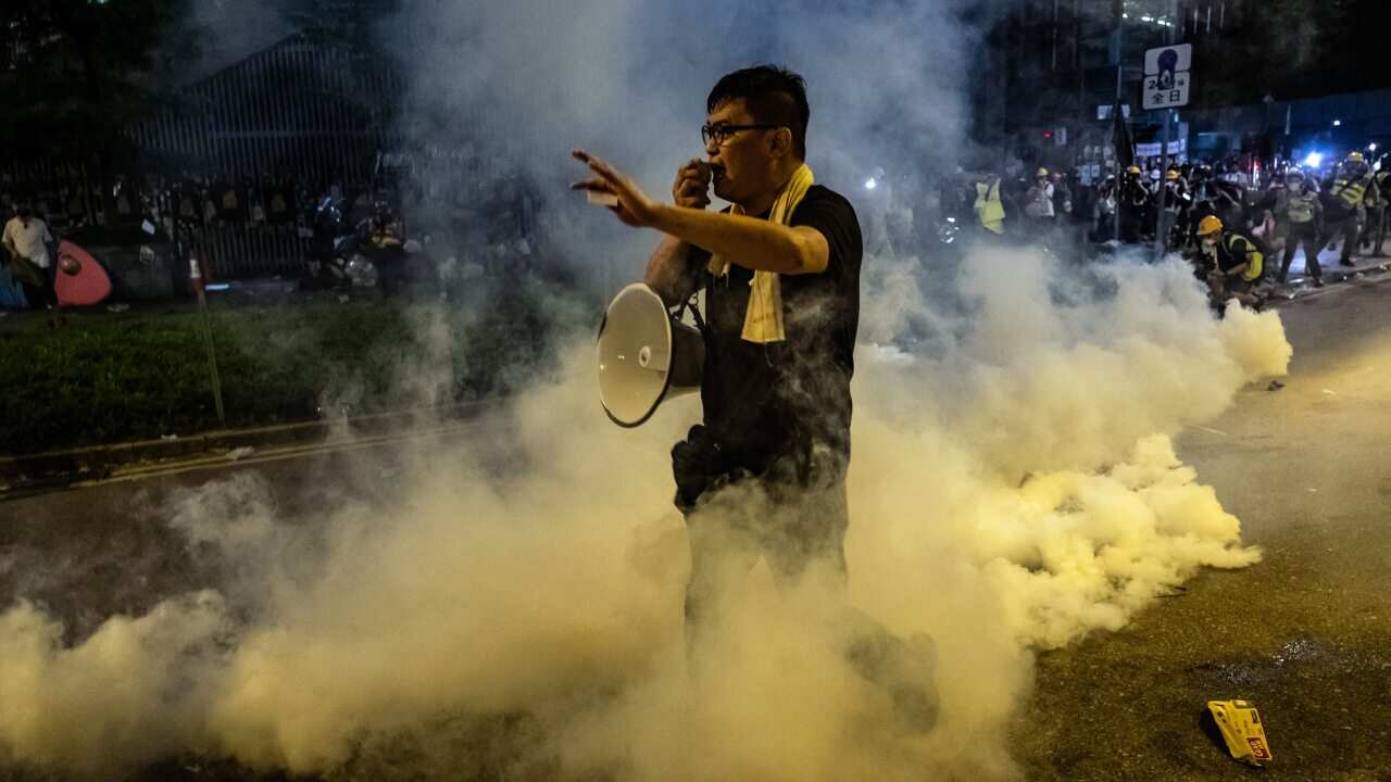 A protester stands in a cloud of teargas outside the Legislative Council in Hong Kong shortly after midnight on Tuesday morning, July 2, 2019.
