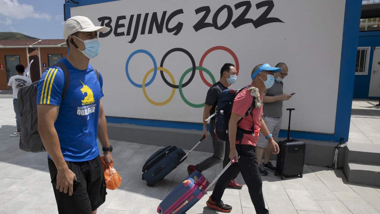 Visitors walk past by the Winter Olympics Beijing 2022 logo in Chongli, in northern China's Hebei Province.