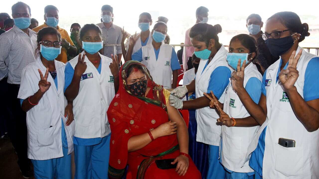 A beneficiary receives a dose of COVID-19 vaccine as India completes 100 crore vaccination