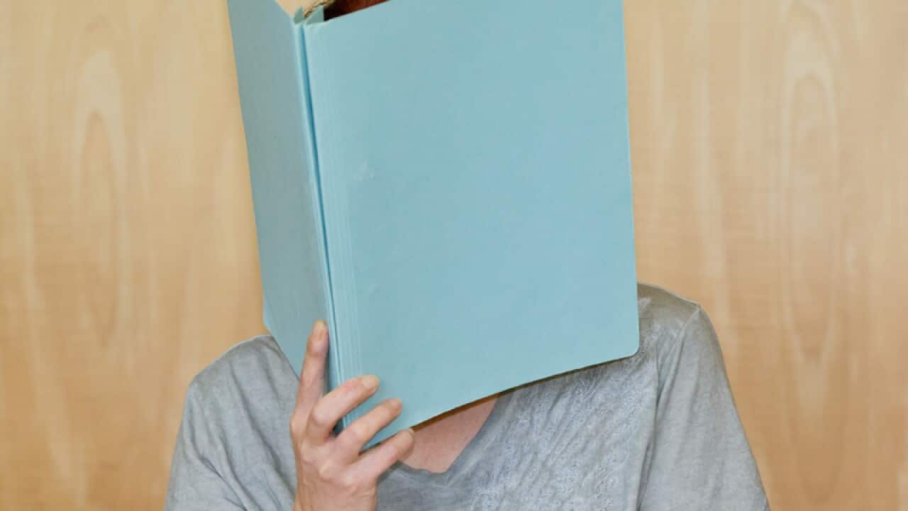 A mother covers her face while facing a German Court