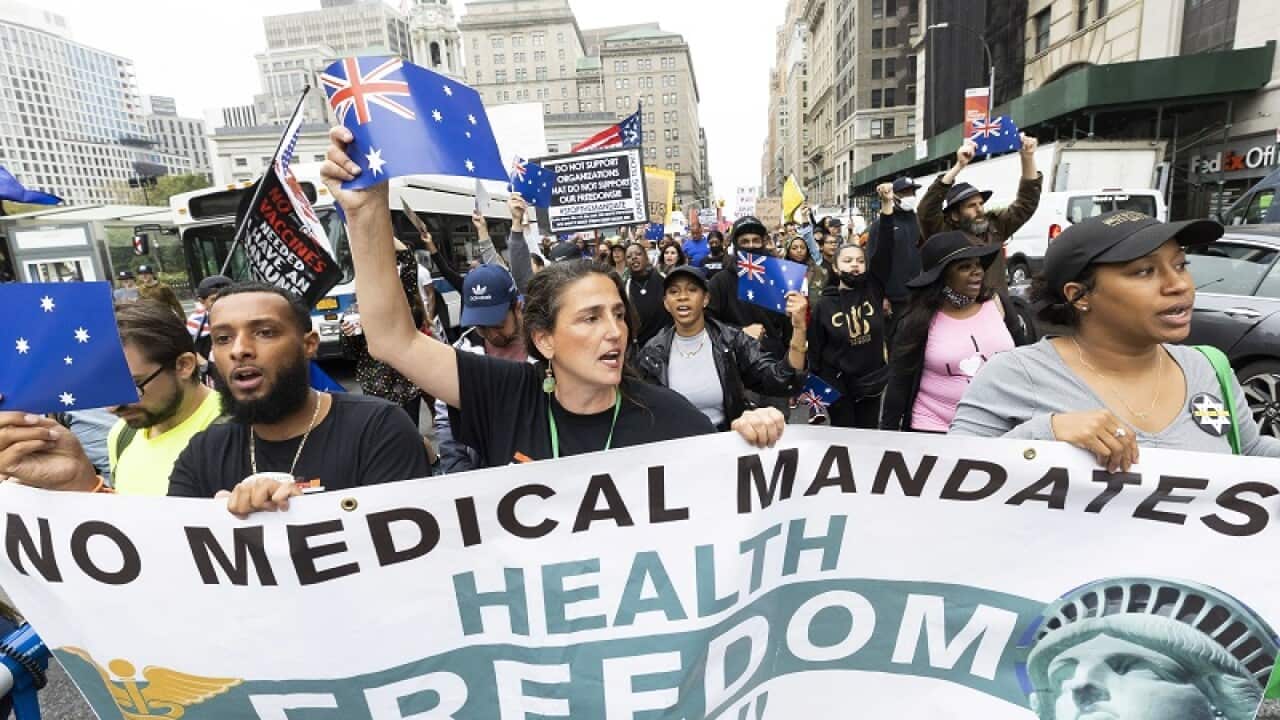 New Yorkers against a vaccine mandate wave Australian flags at a protest on Monday (local time).