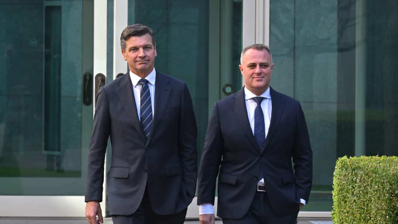 Angus Taylor and Tim Wilson in suits in front of an office building.