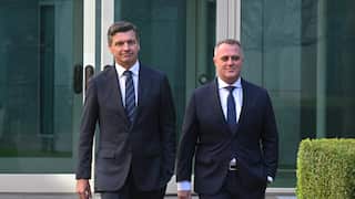 Angus Taylor and Tim Wilson in suits in front of an office building.