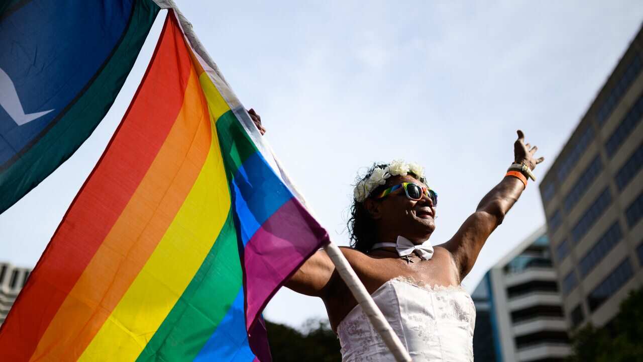 A participant waves a flag ahead of the 42nd annual Gay and Lesbian Mardi Gras parade in Sydney, Saturday, February 29, 2020. (AAP Image/James Gourley) NO ARCHIVING