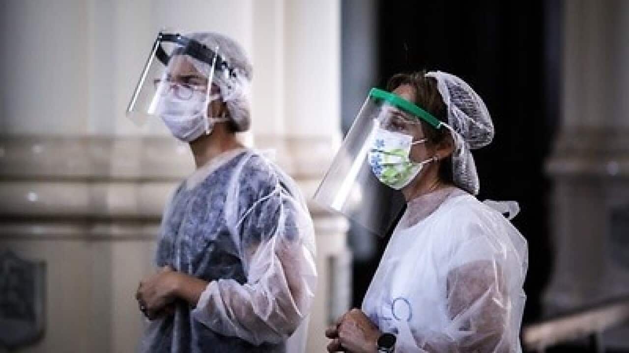 Nurses pray before applying vaccines against flu