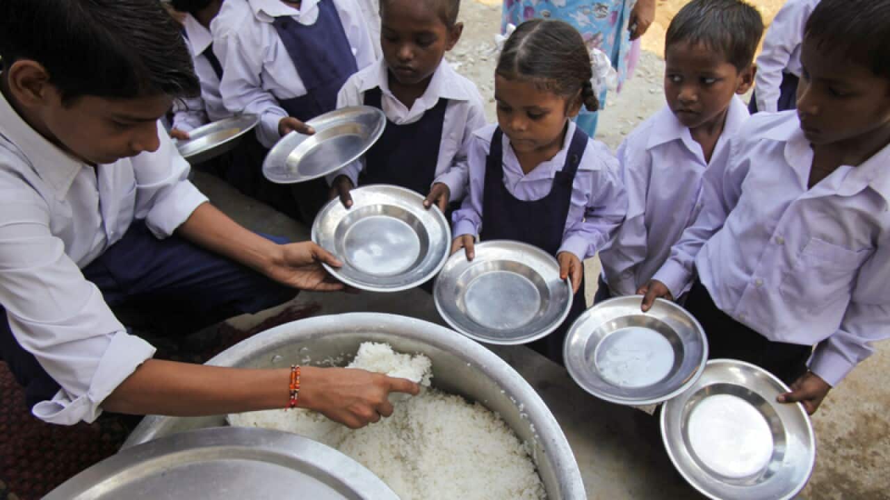 School children receive a free midday meal at a government school