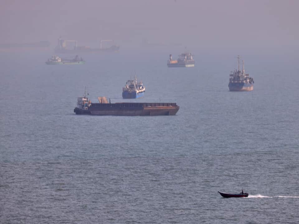 A large number of ships float in a large body of water.