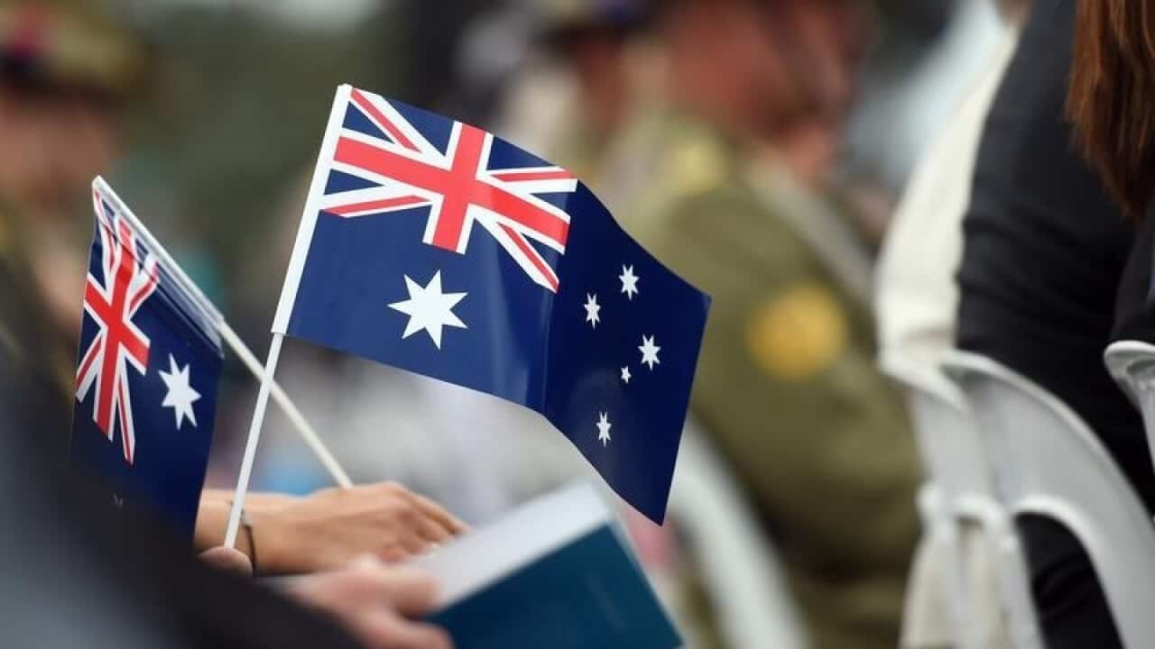 People hold flags at an Australia Day citizenship event.