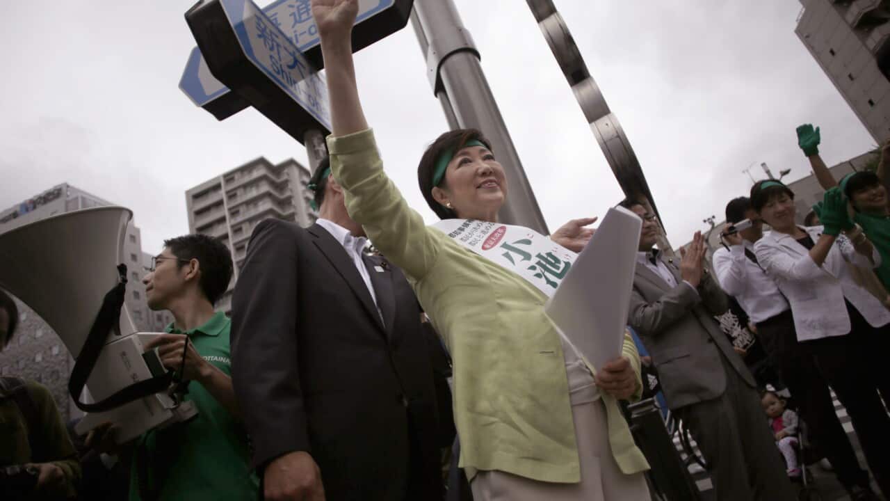 Yuriko Koike, left, former Defense Minister and candidate for the Tokyo's gubernatorial election, waves passerby during her election campaign at Tsukiji.
