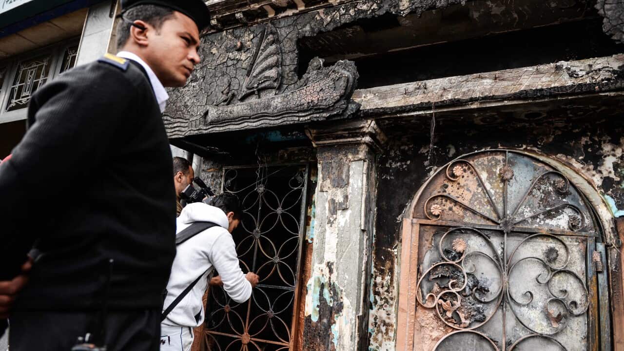 A member of the Egyptian security services stands guard at the site of an attack on a restaurant in the Agouza neighborhood of Cairo