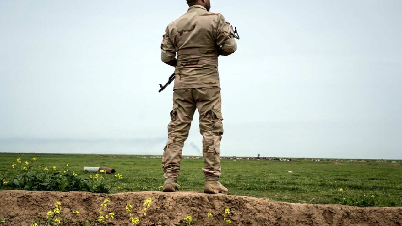 A soldier stands guard on the border of Iraq and Syria