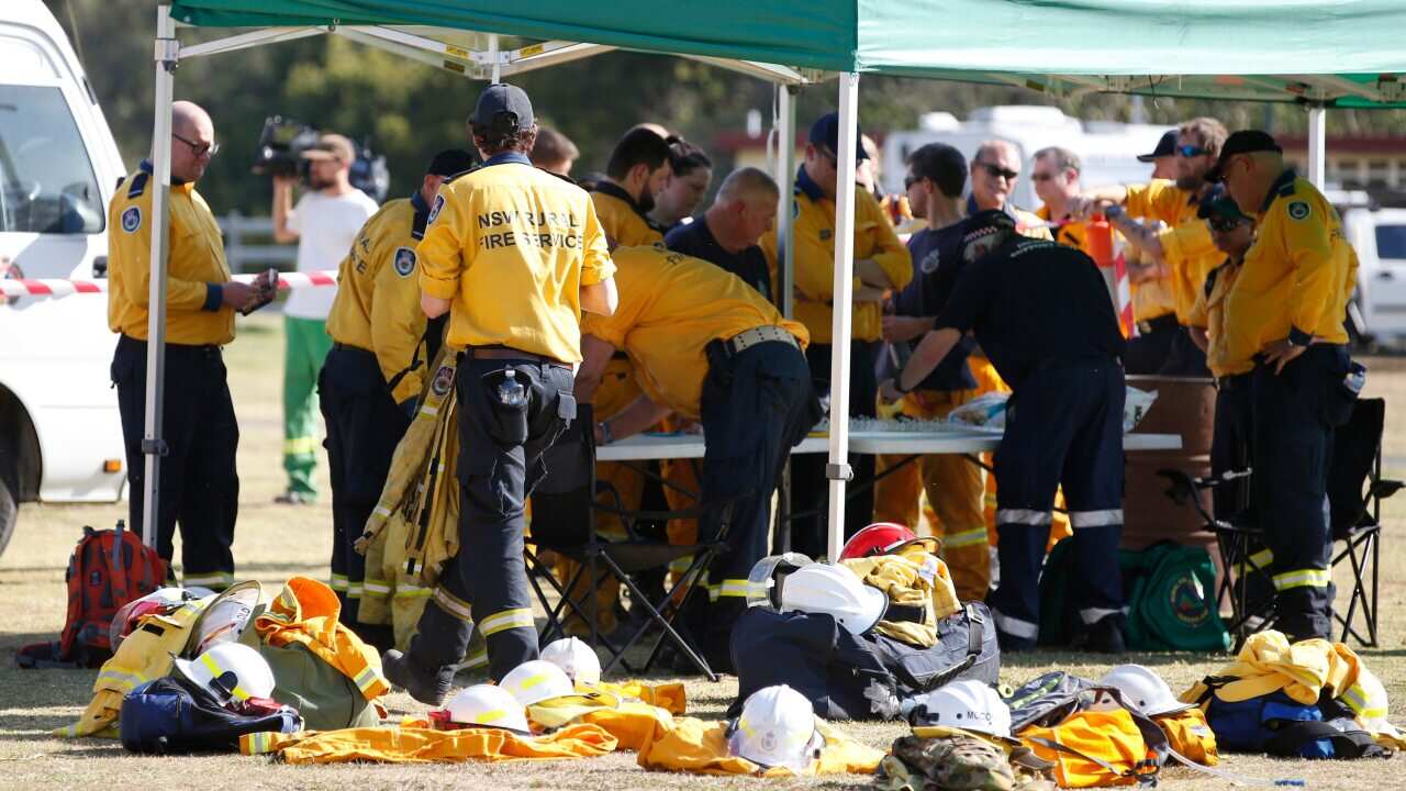 Fire and Emergency crews from NSW prepare to join their Queensland counterparts in the ongoing bushfire control effort near the rural town of Canungra.