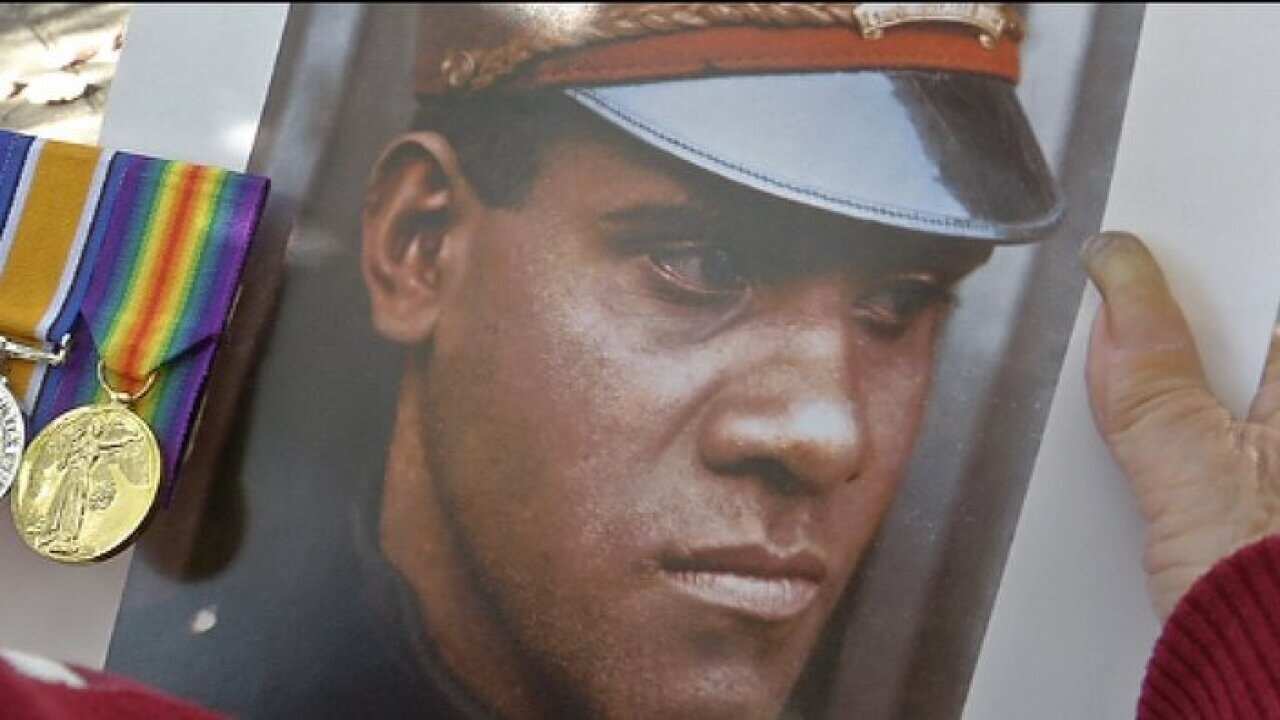 Lorraine Wilson holds a picture and the war medals of her father, Roland Carter