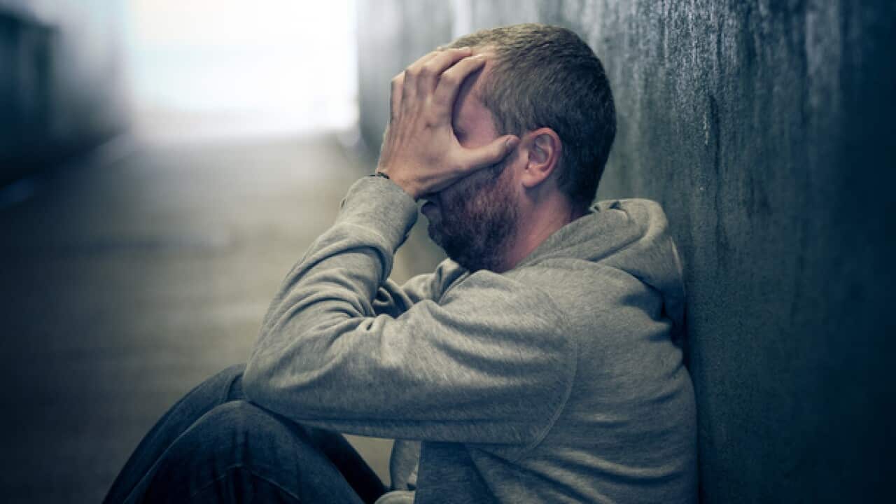 Young homeless caucasian male sitting in dark subway tunnel