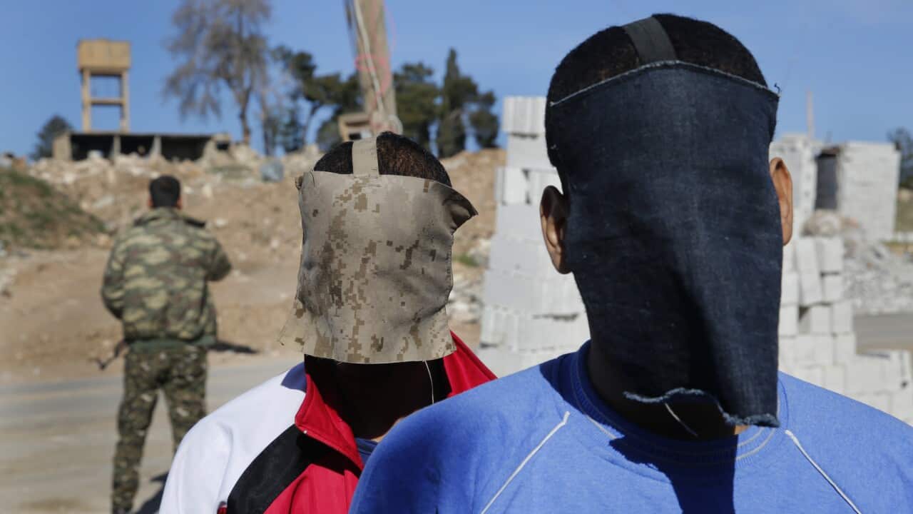 A Kurdish security officer escorts Alexanda Amon Kotey and El Shafee Elsheikh, who were allegedly among four British jihadis who made up 'the Beatles'.