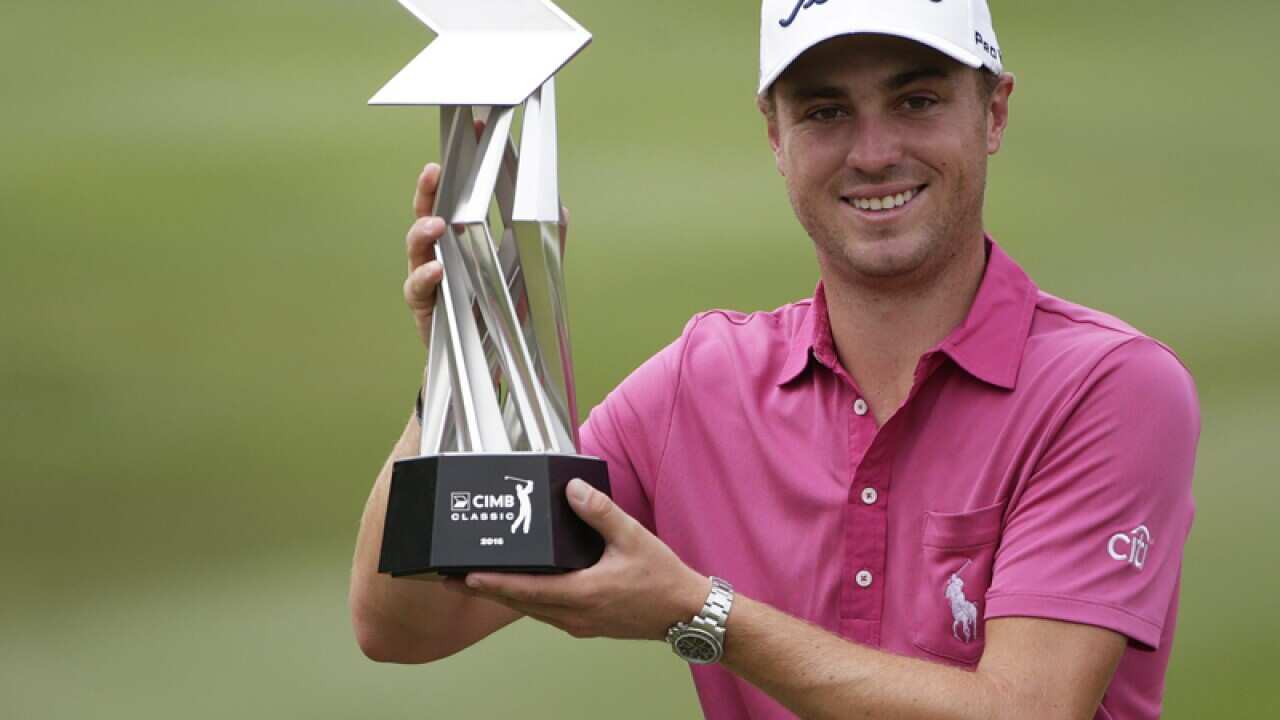 Justin Thomas of USA poses with the trophy
