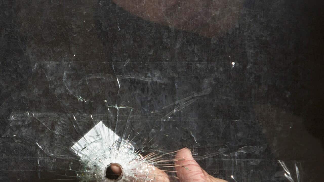 An ultra-Orthodox Jewish youth looks at a bullet hole at a synagogue.