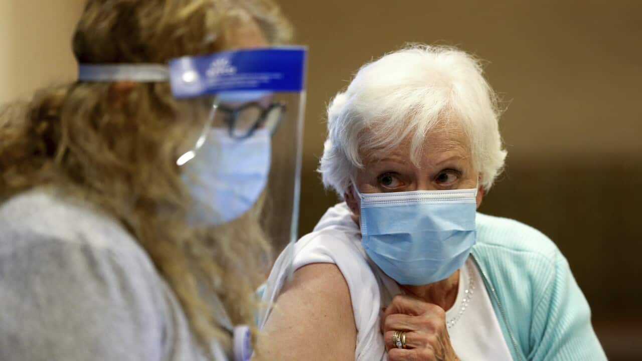 A woman receives her first dose of the COVID-19 vaccine