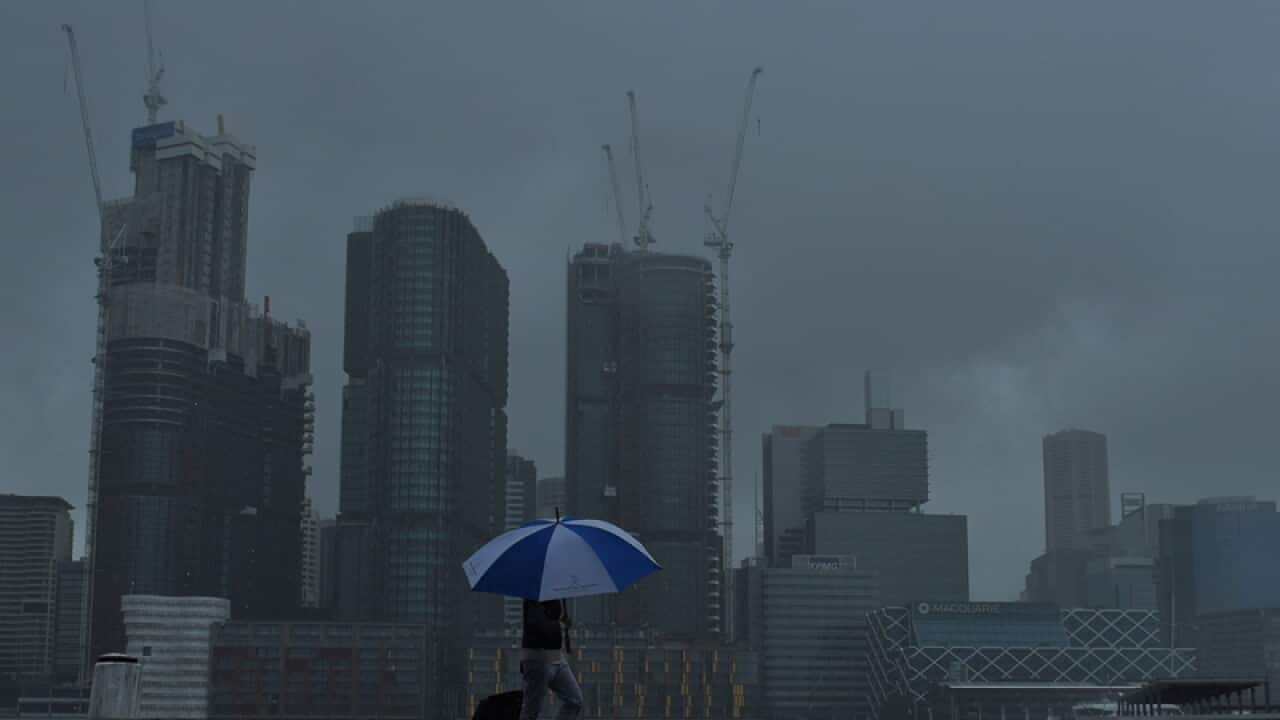 A woman walks past the Barangaroo worksite in Sydney