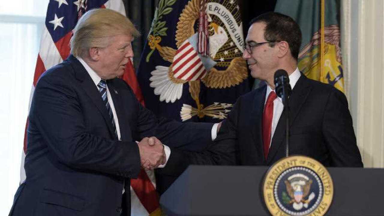 President Donald Trump shakes hands with Treasury Secretary Steven Mnuchin at the Treasury Department in Washington, Friday, April 21, 2017.