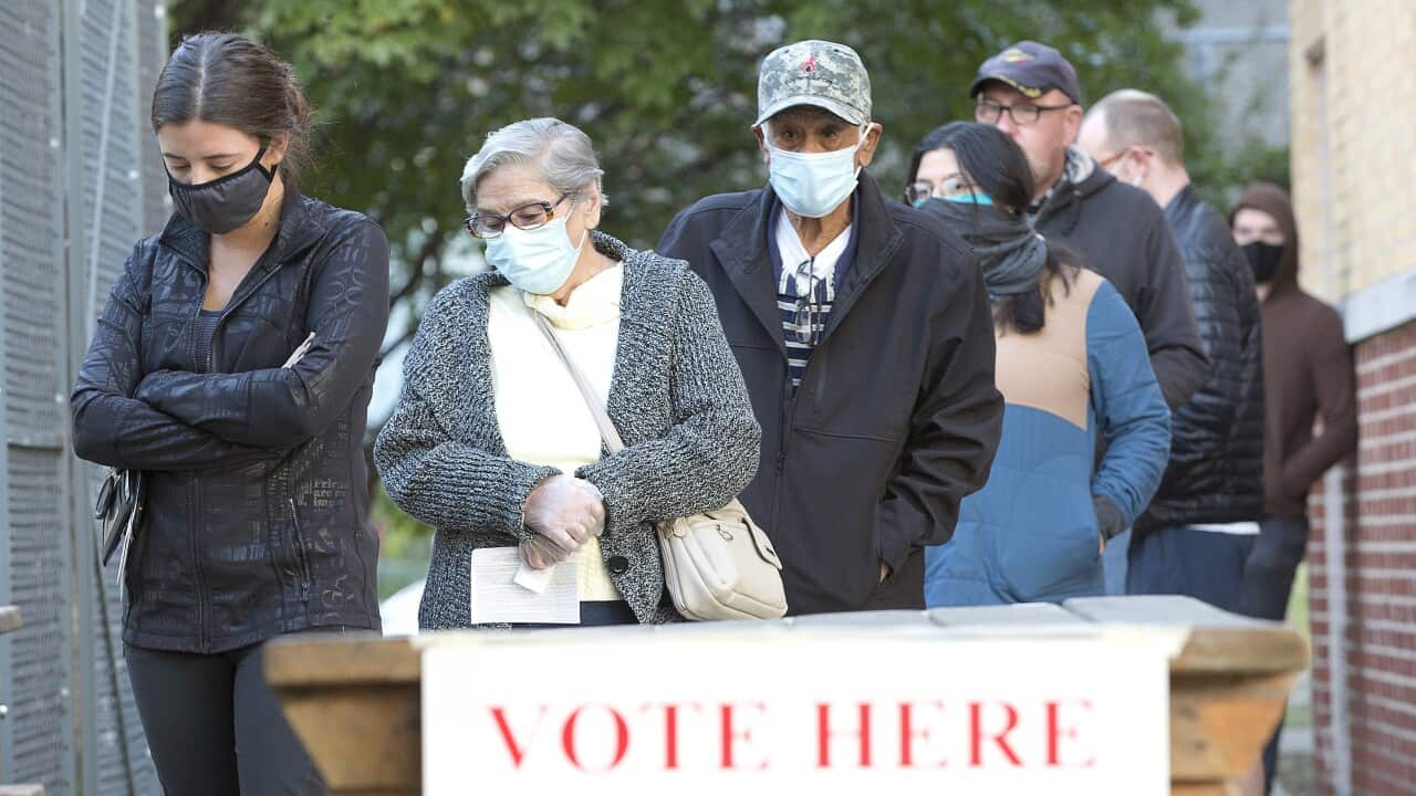 Voters wait in line before dawn and before the doors open at a polling location in Fort Worth, Texas, 3 November 2020.